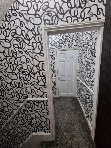 Stairway and hallway wallpaper project showcasing Squiggle design, adding playful movement, visual interest, and a clean modern finish across the entire upper space.