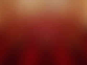 Empty theater with plush red chairs and small side tables, each with a dimly lit red lamp. Ornate ceiling and walls create a classic ambiance.