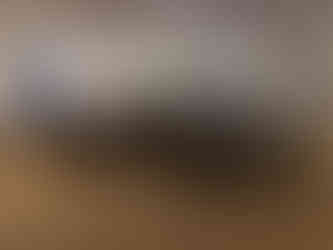 Elegant dining room with arranged tables and chairs, festive wreaths on walls, and soft lighting. White tablecloths, red floral centrepieces.