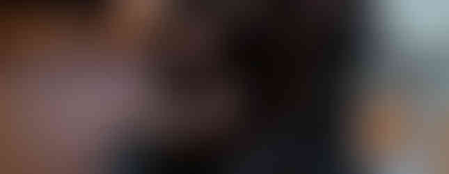 Small Christmas tree with decorations and hanging notes, adorned with blue lights. Set in a cosy room with a painting in the background.