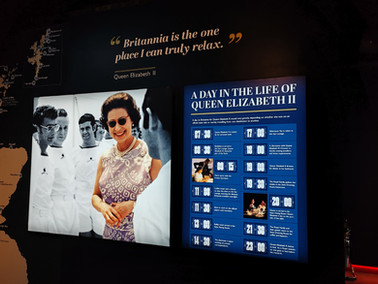 Display featuring two panels: one shows a historical photo of a smiling Queen Elizabeth with men in white uniforms. The other lists a royal schedule.