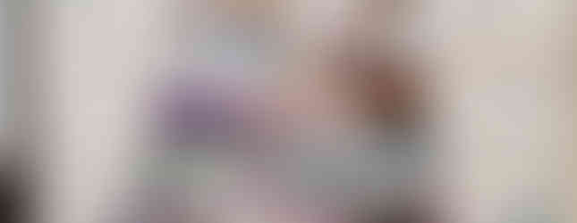 Tapestry of stacked colorful stones (cairn) with patterns and images, set on a white background with wavy lines. Vibrant and intricate.