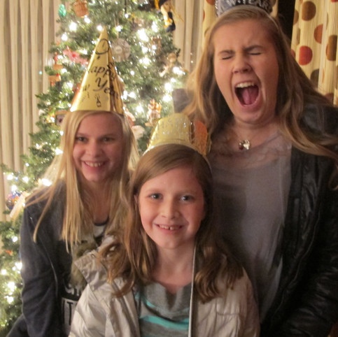 Three girls wearing New Year's party hats