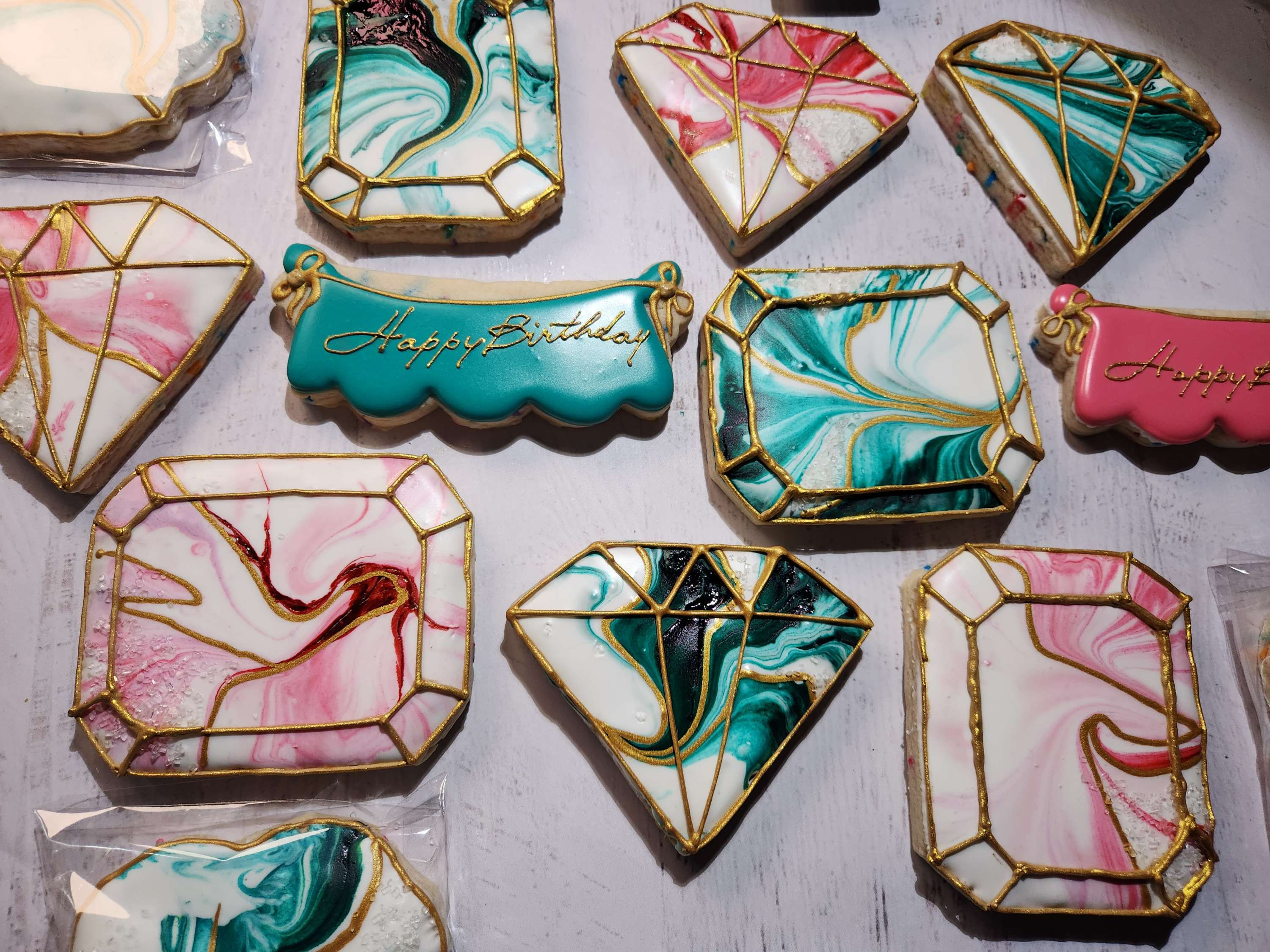 Gemstone cookies with marbled pink, teal, and gold icing