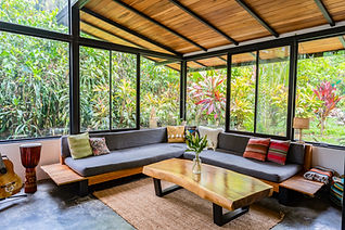 Contemporary glass and steel home with green roof, tropical garden, and forest backdrop in the Chirripó Valley, Costa Rica.