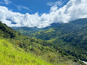 Panoramic mountain view from a property in the Chirripó Valley, with rolling green hills and sun-drenched pastures overlooking San José de Rivas, Costa Rica.