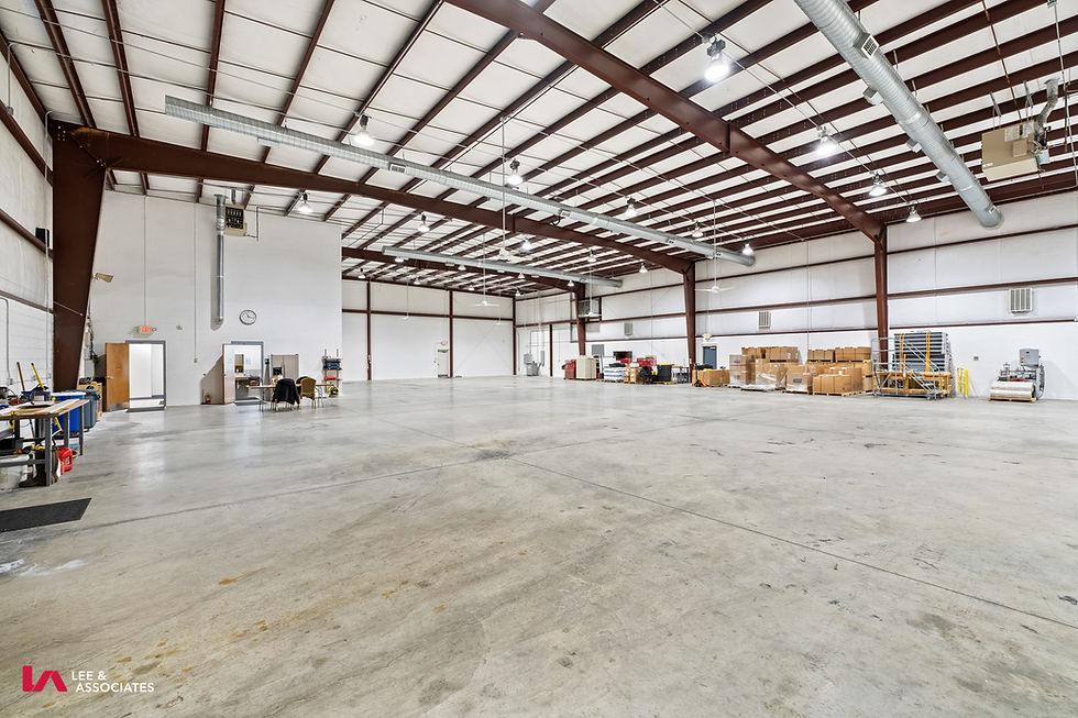wide interior of an empty industrial warehouse, neutral colors, landscape