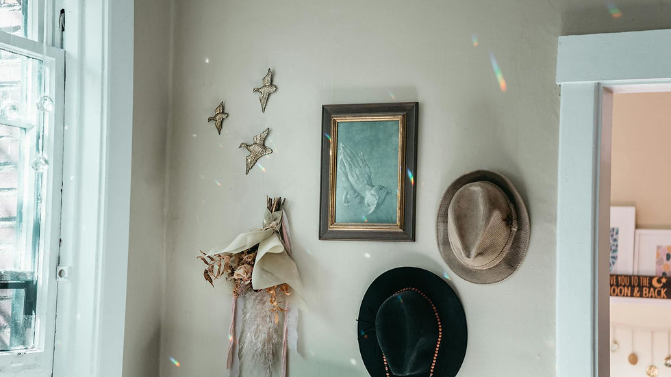 Charming vintage interior featuring hats, wall art, and dried floral decor.