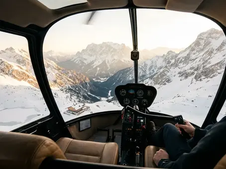 Luxuriöser Hubschrauber fliegt über die schneebedeckte Zugspitze bei klarem Himmel, Sonnenlicht taucht die Alpen in warme Farben, Blick von schräg oben auf Gipfel
