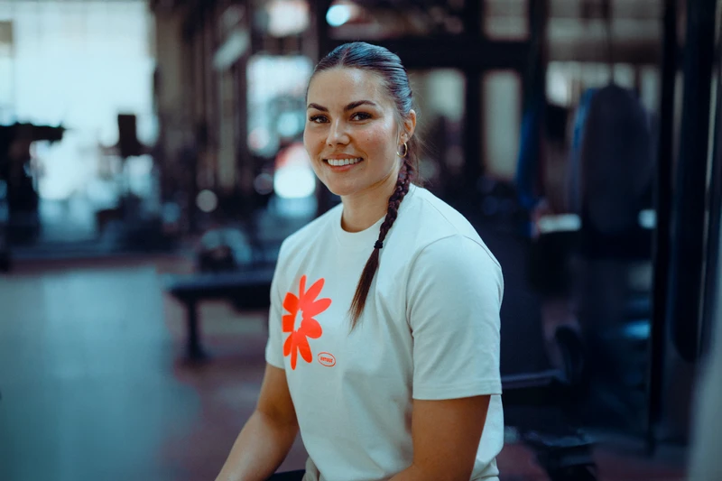 Coach smiling and sitting on bench press