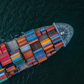 Aerial view of container ship transporting manufactured goods as part of international shipping and global supply chains.