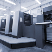 Industrial commercial printing press producing printed sheets for custom POS displays and retail packaging.