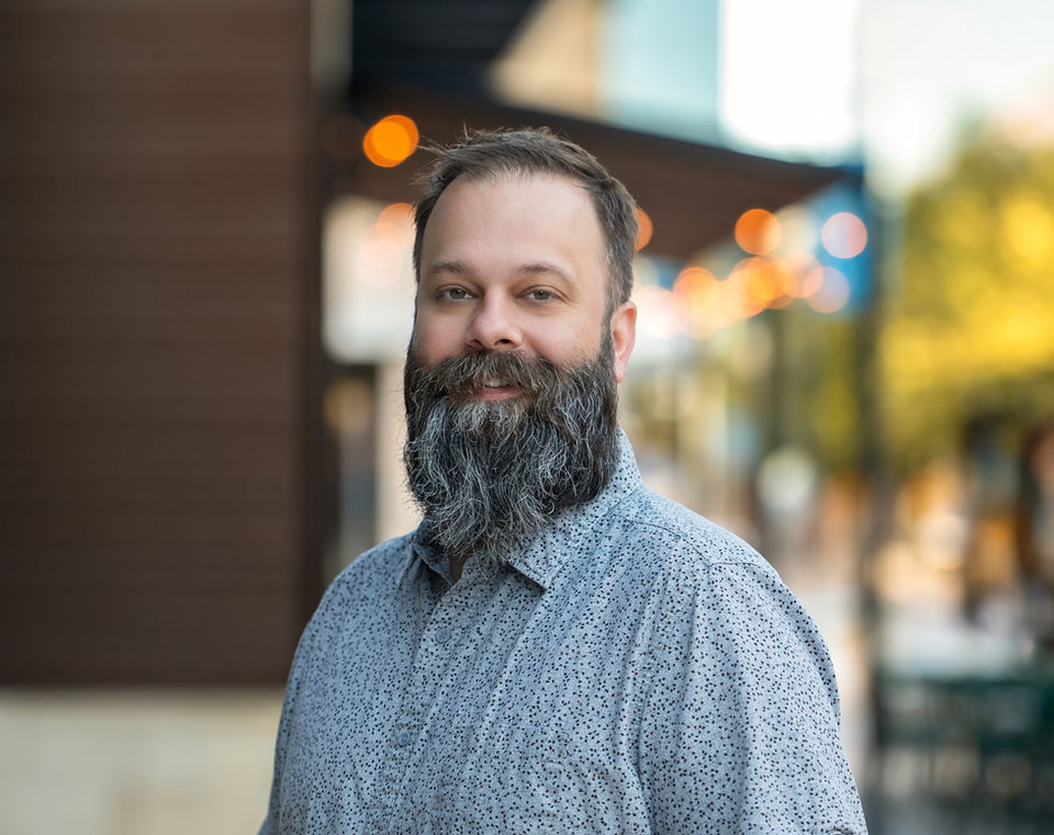 Modern professional headshot of man with beard and casual style, photographed in downtown McKinney.