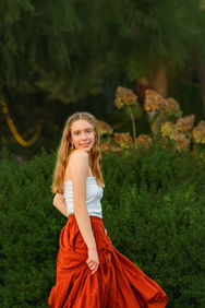 North Texas senior portrait featuring a senior twirling in a flowing skirt at Grapevine Botanical Gardens