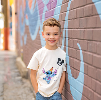 McKinney family photographer captures a colorful 5th birthday session with bright mural, balloon, and joyful child.
