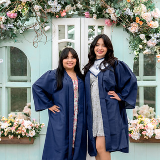 Close-up of a smiling senior girl framed by florals and greenery at the Lemon Drop Studio greenhouse location in McKinney.