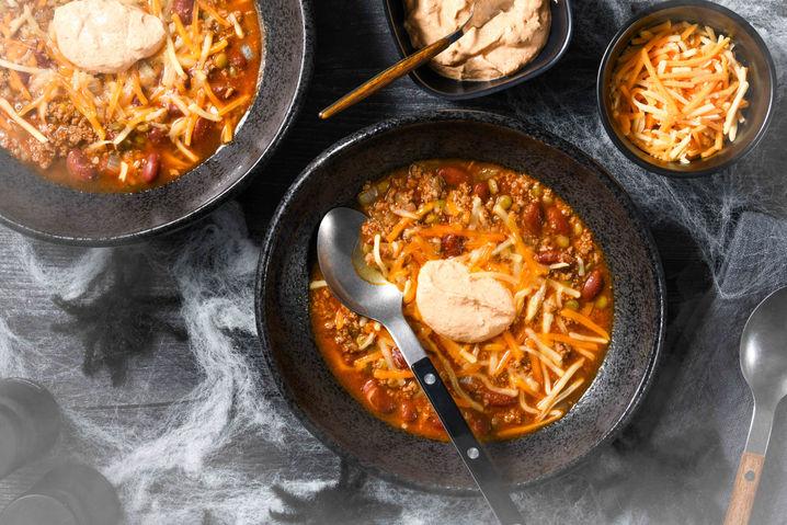 Three-quarter angle braised dish in cast iron skillet with steam dark moody lighting commercial food photography Chicago