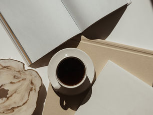Coffee and an open notebook — image for “You Stopped Wanting Things. Welcome to Maintenance Mode.” (EWA Coaching blog).