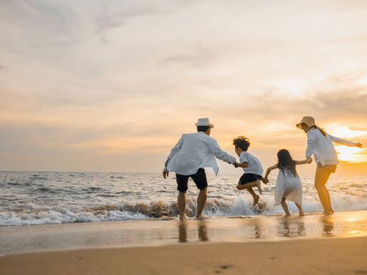 A family playing on the beach at sunset