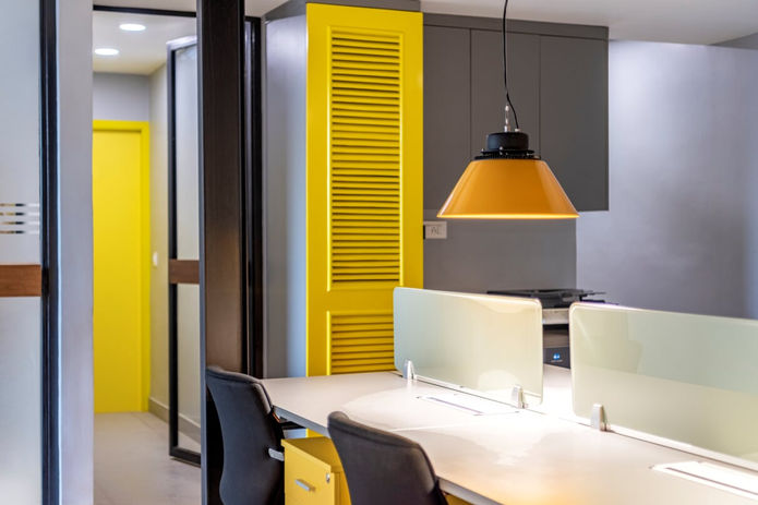 yellow accents for a white office space with the storage shutters serving as wall art 