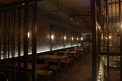 Immersive prison-style dining space with dramatic lighting