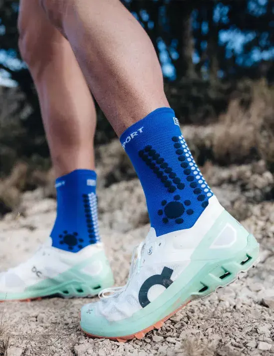 Miniatura: vista frontal de corredor con calcetines altos compressport v4.0 trail color azul