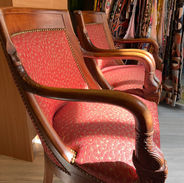 Tissu couleur brique aux légers dessins et clous laiton vieilli pour cette paire de fauteuils de style Empire.