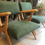 Paire de fauteuils de style scandinave. Le bois des accoudoirs est clair et le tissu est un velours côtelé vert foncé.