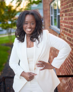Middle-aged Black woman posing for a professional real estate branding photo, looking confident and approachable.