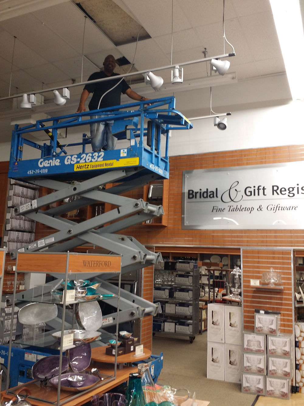 Electrician on a lift installing ceiling lights