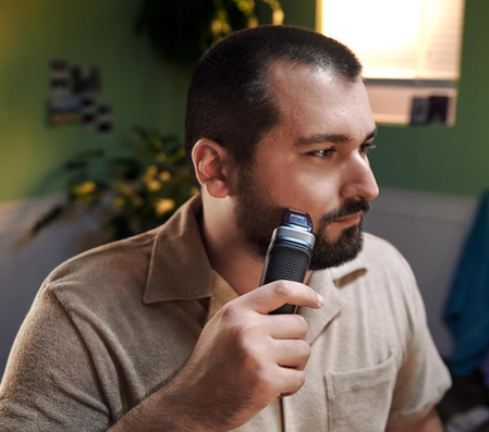 Man shaves beard with Philips Norelco Multigroom Series 5000, close up of face.