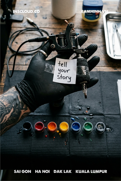 Gloved hand holding a tattoo machine with a note saying Tell Your Story