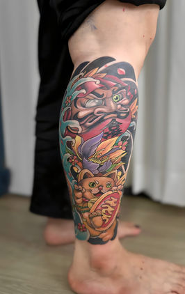 Colorful neo-traditional tattoo on a person's lower leg