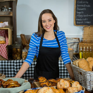 Frau mit blauen Oberteil in Bäckerei.
