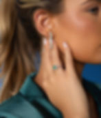 A stunning emerald ring with a diamond halo paired with radiant Bare Brilliance drop earrings from K. Hollis Jewelers in Batavia, IL