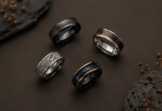 A finished custom engagement ring next to its wax mold and sketches