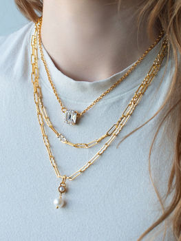 Mariana layered gold-tone necklaces featuring a clear rectangular crystal pendant, mixed chain links and a pearl drop pendant.