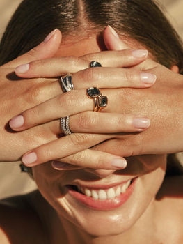 Model wearing stacked TI SENTO rings with blue stones and crystal accents