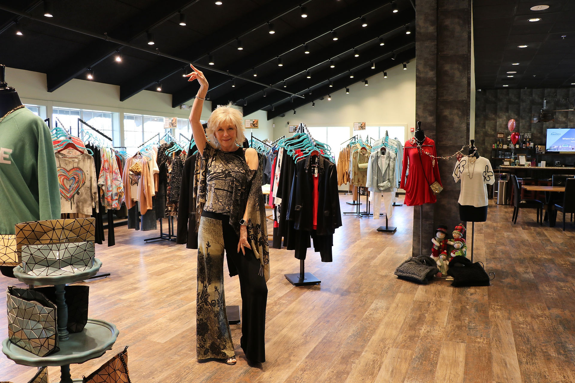 Karen Hollis shopping the boutique, surrounded by clothing racks during a seasonal sale.