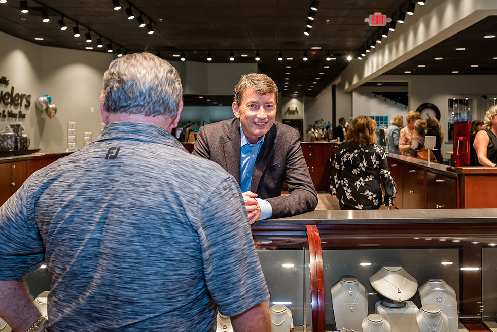 A husband shopping for gemstone jewelry for his wife at K. Hollis Jewelers in Batavia, IL