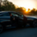 a driver opening the door for a client to step into the black car.jpg