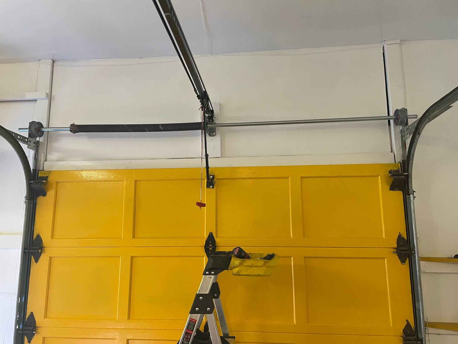 Yellow garage door with track and ladder; Door Maintenance; Rh Garage Door Repair