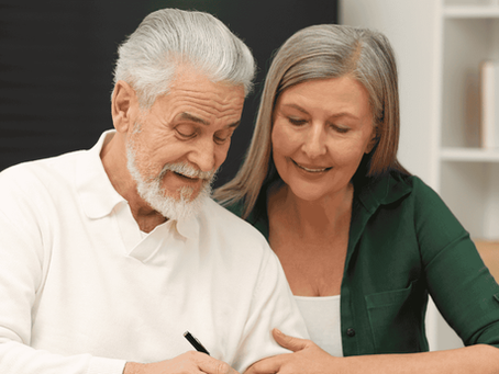 Casal de idosos assinando documentos com orientação profissional para resolver herança de forma tranquila e sem brigas na justiça