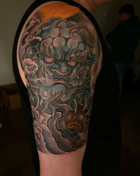 custom foo dog tattoo on upper arm, tattooed by Fei in Los Angeles CA.