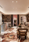 Opulent room with ornate floral rug, sofa, and jewelry displays
