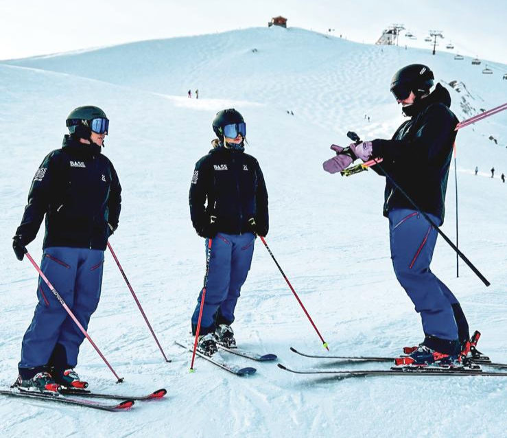 Wide-angle view of a ski instructor leading a skier on a gentle piste in the French Alps