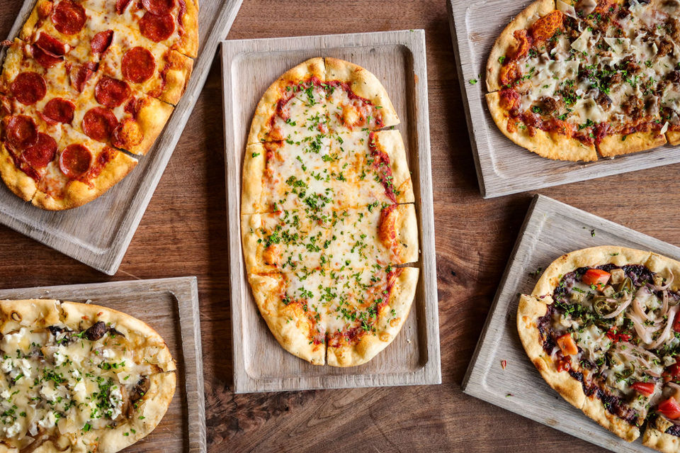 Variety of pizzas on wooden boards