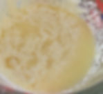 Close-up of a measuring cup with grainy and watery mayonnaise that separated.