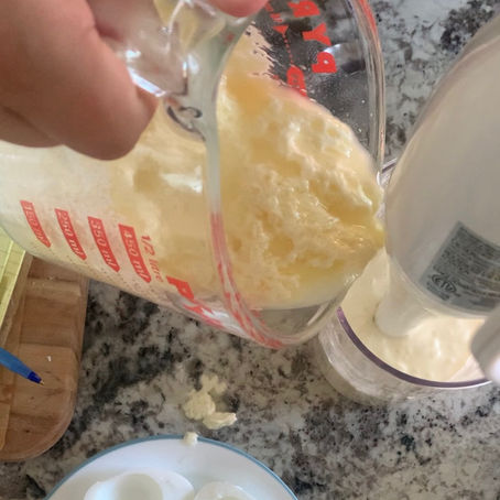 Up close view of narrow transparent container and a hand blender, slowly reincorporating a separated homemade mayonnaise
