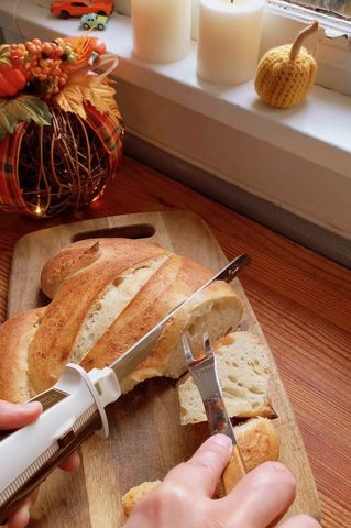 electric knife cuts into bread